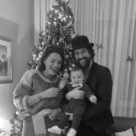 Stefan Kapičić, Ivana Horat and Ivan Kapičić are posing in front of the Christmas tree at their home.